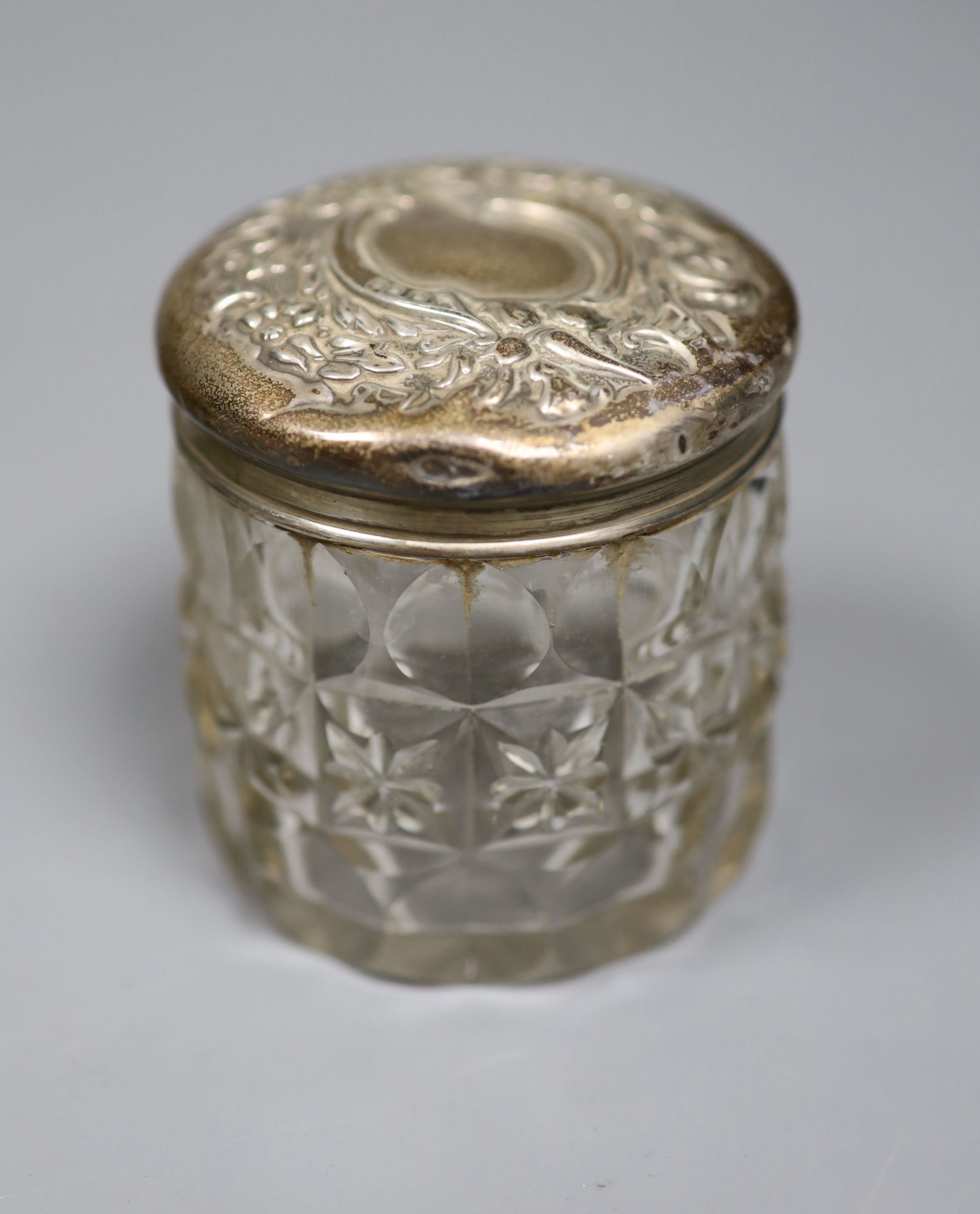 A George VI silver christening mug, a silver mounted cigarette box, a silver mounted scent bottle and toilet jar.